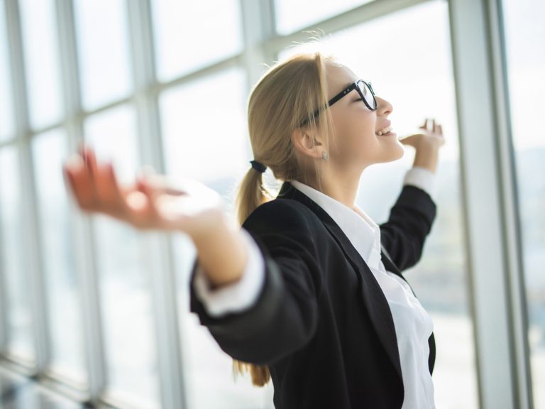 Business woman excited hold hands up raised arms celebrate victory . concept winner success in modern office