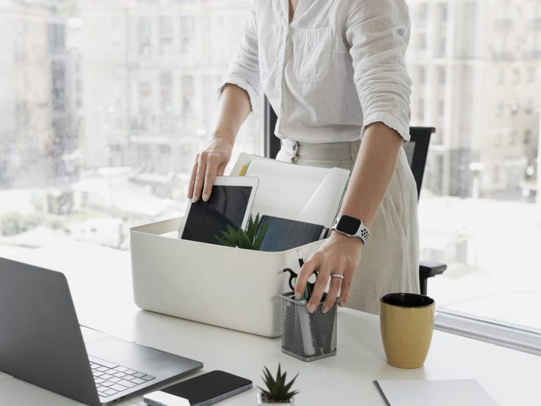 side-view-woman-packing-desk-items