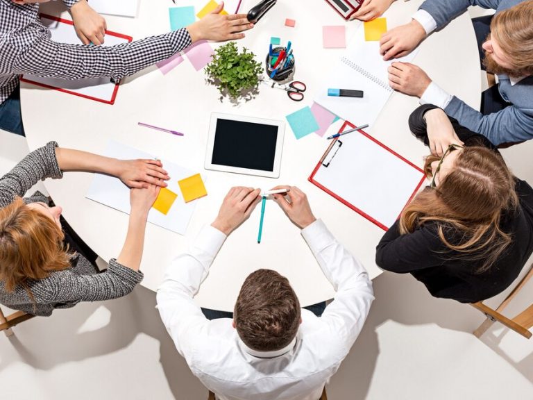 team-seduto-dietro-la-scrivania-controllando-i-rapporti-parlando-vista-dall-alto_155003-27524